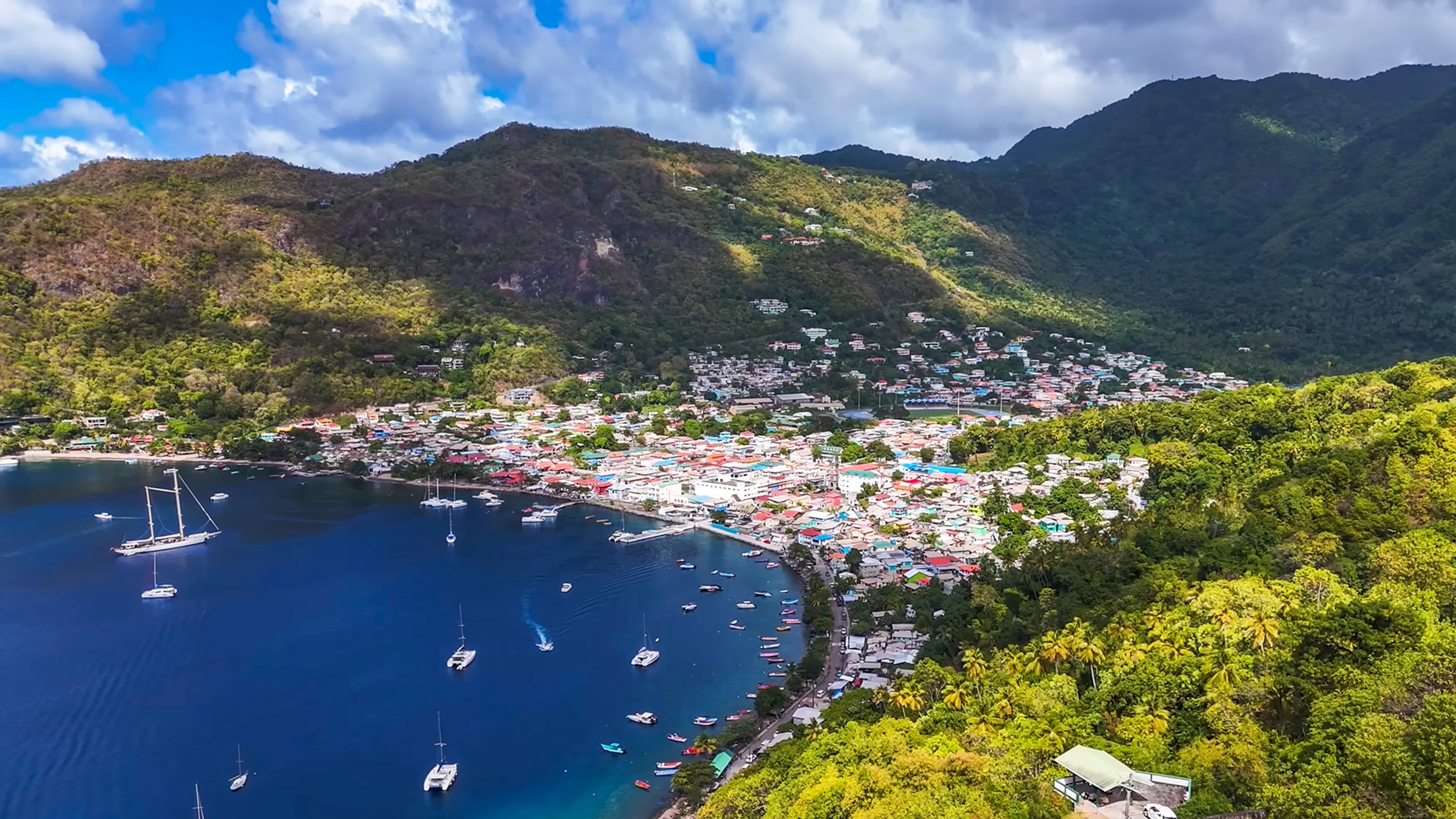 A Caribbean coastal town beside a sheltered bay and forested mountains, illustrating the setting associated with Saint Lucia citizenship